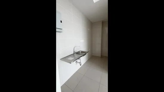 Laundry features: stainless-steel sink, chrome faucet, white tiled walls, grey floor tiles, wall-mounted soap dispenser, single wall light fixture; style: modern.