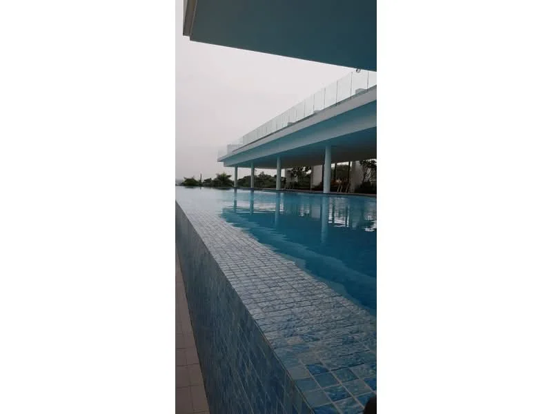 Exterior type: swimming pool deck; features: infinity pool, glass railing, tiled pool edge, surrounding landscaping, modern architecture, pool deck with loungers; style: modern.
