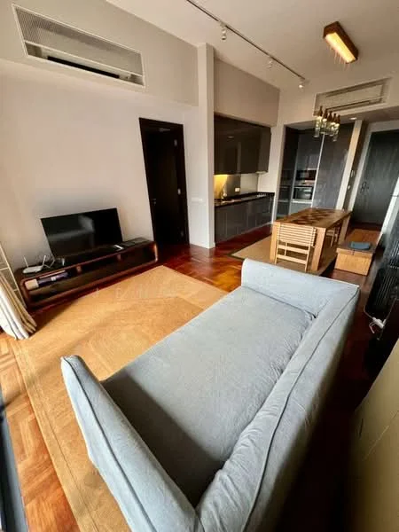 Living features: 3-seater fabric sofa in light grey, wooden coffee table, TV console, wall-mounted TV, recessed downlights, wooden flooring, floor-to-ceiling windows with sheer curtains, air conditioning unit, decorative chandelier, area rug; style: modern. Kitchen features: kitchen island, black cabinetry, built-in oven, stainless-steel fridge, induction hob, extractor hood, countertop with bar seating, open shelving; style: modern.
