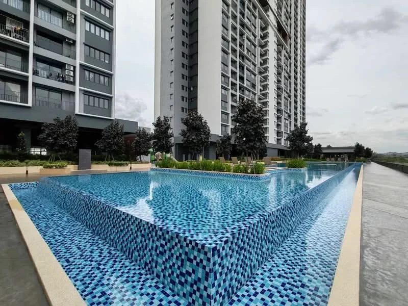 Exterior type: high-rise condominium; features: infinity pool, pool deck with loungers, tiled pool surface with blue mosaic, landscaped garden area, surrounding trees, modern architectural design, concrete pathway, glass balcony railings; style: modern.