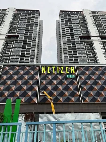 Exterior type: high-rise condominium; features: glass curtain wall, geometric patterned facade, prominent signage, multiple storeys, balconies visible, surrounding greenery, modern architectural design; style: modern.