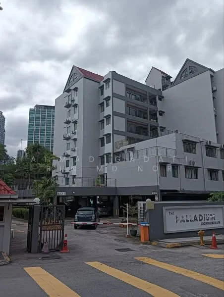 Exterior type: mid-rise condominium; features: grey painted facade, flat roof, approximately 5-storey building, gated entrance, guard house at entrance, driveway with interlocking pavers, landscaped garden area, parking area, signage at entrance, surrounded by mature greenery; style: modern.