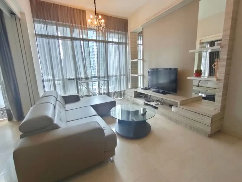 Living features: L-shape sectional sofa in light grey, glass coffee table, wall-mounted TV, TV console with storage, large floor-to-ceiling windows, sheer curtains, chandelier, neutral painted walls, light-colored tiled flooring, decorative plant on console; style: modern; view: city.