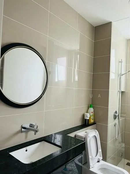 Bathroom features: wall-mounted basin with chrome faucet, black granite countertop, round framed mirror, two-piece toilet, walk-in shower with glass enclosure, chrome shower head, beige tiled walls, grey tiled flooring, shower caddy with cleaning products; style: modern.