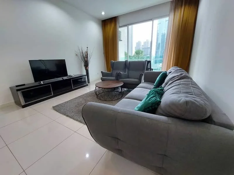 Living features: grey fabric sofa, 2-seater grey sofa, round wooden coffee table, TV console with storage, wall-mounted flat-screen TV, area rug, floor-to-ceiling windows, curtains in mustard yellow, decorative plant in corner, white painted walls, glossy tile flooring, city view from window; style: modern; view: city.