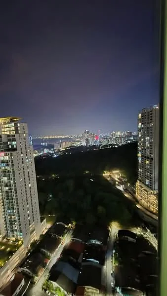 Exterior type: high-rise condominium; features: city skyline view, night lighting, surrounded by greenery, multiple high-rise buildings, urban landscape, visible roadways, lights from buildings and streets; style: modern.