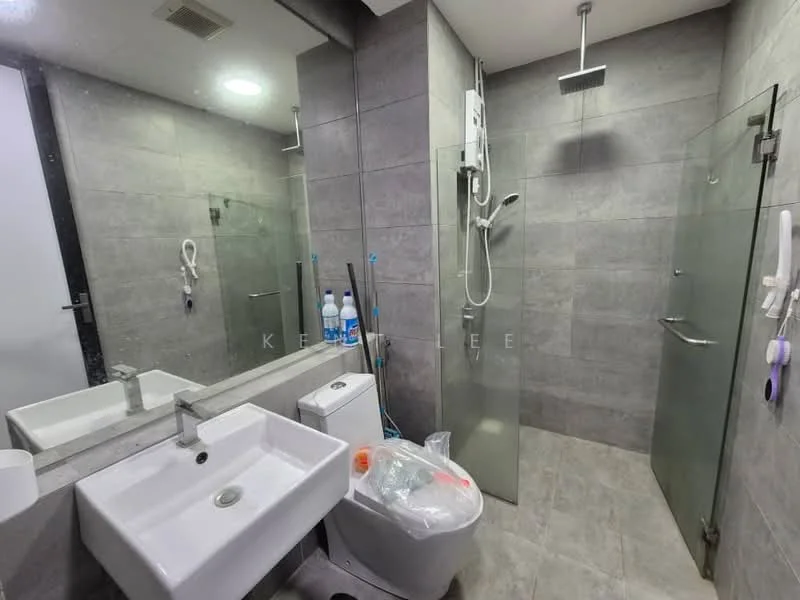 Bathroom features: grey tile flooring, grey tile walls, walk-in shower with glass enclosure, rain shower head, handheld shower, single-bowl ceramic sink, chrome basin mixer faucet, one-piece toilet, mirror above sink, shower wall with glass panel, towel rack, bottled water on floor; style: modern.