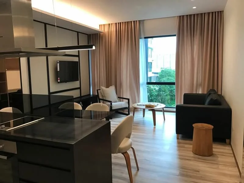 Living features: floor-to-ceiling windows, sheer curtains, light wood flooring, black accent wall, sofa in black, 2-seater fabric sofa in beige, coffee table, TV mounted on wall, decorative wall paneling, recessed ceiling lights, area rug, wooden stool; style: modern; view: garden. Kitchen features: black countertop, stainless-steel sink, built-in stove, kitchen cabinetry, open shelving, bar seating with stools; style: modern.