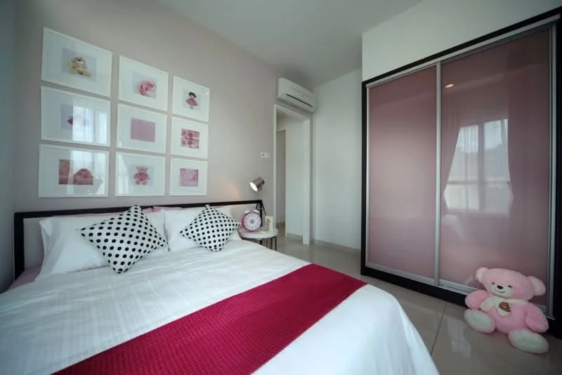 Bedroom features: queen-size bed with white bedding, pink throw blanket, black and white polka dot decorative pillows, framed artwork on walls, sliding wardrobe with frosted glass doors, floor-to-ceiling window with sheer curtains, wall-mounted air conditioning unit, ceramic tile flooring, pink teddy bear on the floor; style: modern.