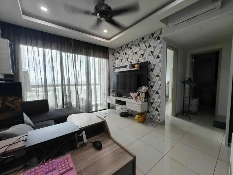 Living features: grey fabric sectional sofa, black TV console, wall-mounted TV, geometric patterned accent wall, white painted walls, recessed ceiling lights, 5-blade ceiling fan, floor-to-ceiling windows with sheer curtains, white tile flooring, decorative items on TV console, computer desk with keyboard, pink gaming keyboard; style: modern; view: city. Room features: doorway leading to another room, laundry rack visible in hallway.