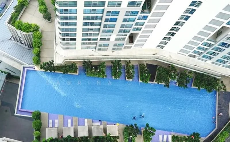 Exterior type: high-rise condominium; features: infinity pool, pool deck with loungers, landscaped greenery, tropical landscaping, glass curtain wall facade, surrounded by mature trees; style: modern.