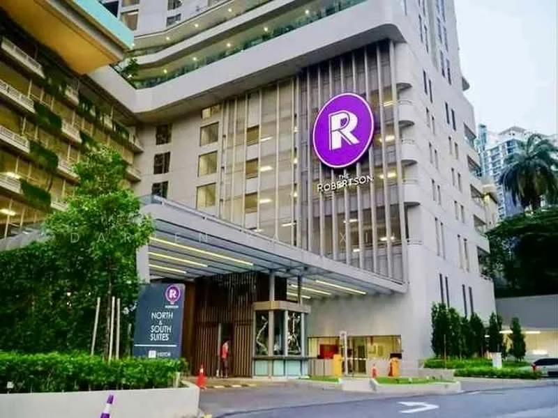 Exterior type: high-rise condominium; features: glass curtain wall, white painted facade, recessed balconies, feature lighting at night, double-volume main lobby, landscaped entrance with greenery, signage with logo, paved driveway, surrounded by mature greenery; style: modern.