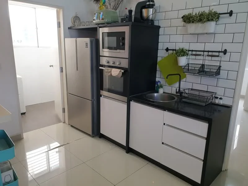 Kitchen features: stainless-steel fridge, built-in oven, microwave, black granite countertop, single-bowl stainless-steel sink, chrome pull-down faucet, white cabinetry with flat-panel design, tile backsplash with white and black pattern, open shelving, wire storage baskets, green wall-mounted organizer, ceramic tile flooring, window with natural light; style: modern.
