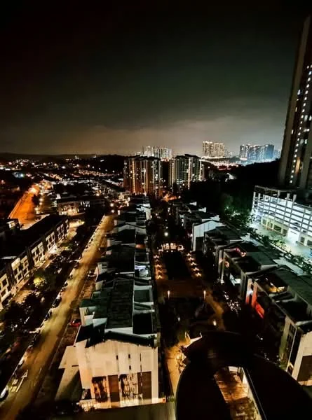 Exterior type: high-rise condominium; features: city skyline view, nighttime lighting, surrounding residential buildings, street view with cars, manicured landscaping, multiple storey buildings, urban setting; style: modern.