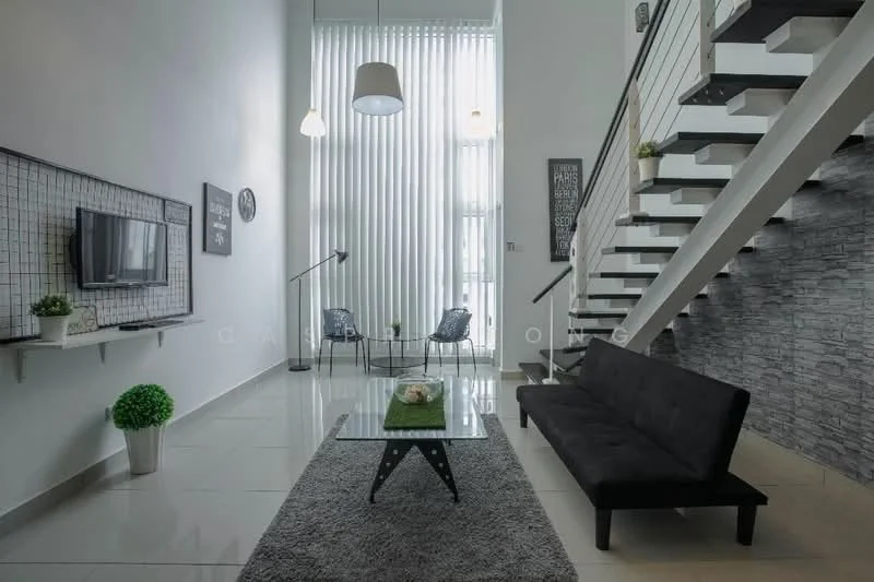 Living features: black fabric sofa, glass coffee table, area rug with geometric pattern, wall-mounted TV, white painted walls, grey accent wall with stone cladding, large floor-to-ceiling windows with sheer curtains, recessed downlights, hanging pendant light, decorative wall clock, indoor plants in ceramic pots, stainless-steel railing on staircase; style: modern.