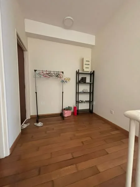 Room features: wood flooring, white painted walls, ceiling light fixture, clothes drying rack, black shelving unit, pink storage basket, door leading to another room; style: modern.