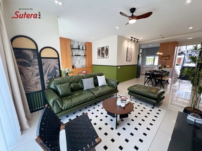 Living features: green leather 3-seater sofa, black and white area rug with geometric pattern, wooden coffee table, 2 black leather chairs, ceiling fan with light, wall-mounted artwork, green accent wall, white painted walls, recessed downlights, open shelving with decorative items; style: modern. Dining features: wooden dining table, 4 upholstered dining chairs, pendant lighting above dining table, open kitchen layout, white cabinetry, black countertop; style: modern.