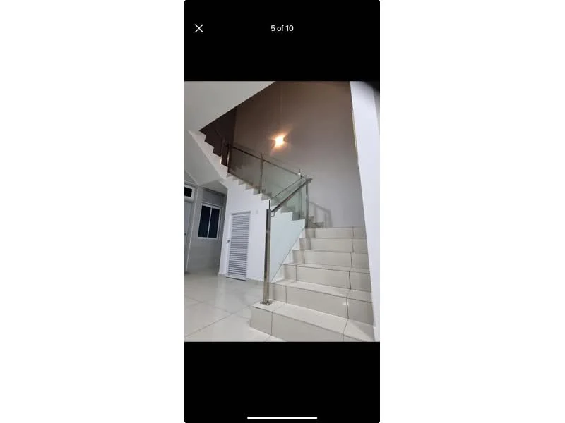 Room features: staircase with white tiled steps, glass railing, recessed ceiling light, white painted walls, large windows, neutral flooring, open space design; style: modern.