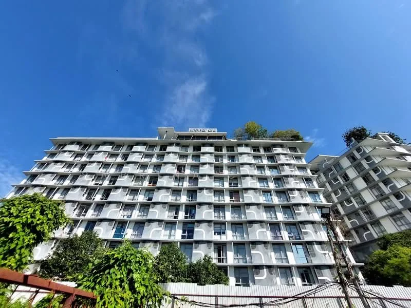 Exterior type: mid-rise condominium; features: white painted facade, balconies with glass railings, approximately 5-storey, landscaped greenery at base, signage on top of building, windows with shutters, surrounded by trees; style: modern.