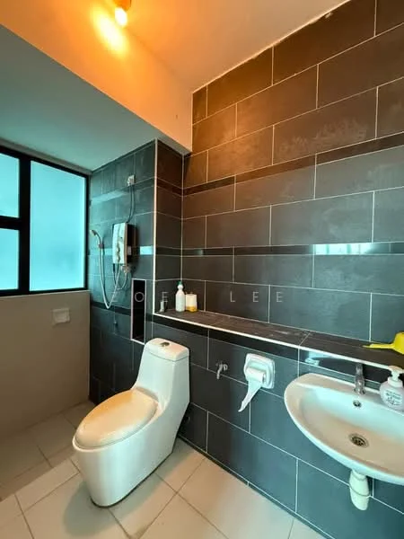 Bathroom features: grey tile cladding on walls, white tiled flooring, walk-in shower with glass partition, chrome shower head, chrome handheld shower, white toilet, white basin sink, wall-mounted faucet, large window for natural light, soap dispenser, toilet paper holder; style: modern.