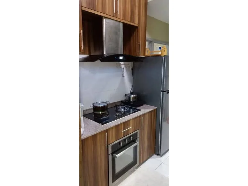 Kitchen features: wood cabinetry, granite countertop, stainless-steel range hood, 4-burner gas hob, built-in oven, stainless-steel fridge, white tiled backsplash, ceramic tile flooring; style: modern.