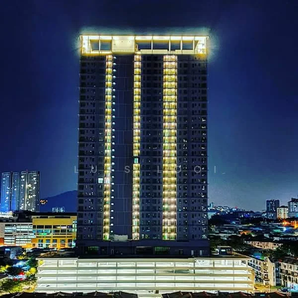 Exterior type: high-rise condominium; features: glass curtain wall, illuminated facade, recessed balconies, approximately 20-storey high-rise, surrounded by urban landscape, parking deck visible at the base; style: modern.