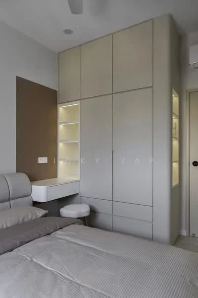 Bedroom features: queen-size bed with grey bedding, built-in wardrobe with light grey finish, integrated lighting in wardrobe, study desk with white surface, white stool, accent wall in brown, ceiling fan, light-colored flooring; style: modern.
