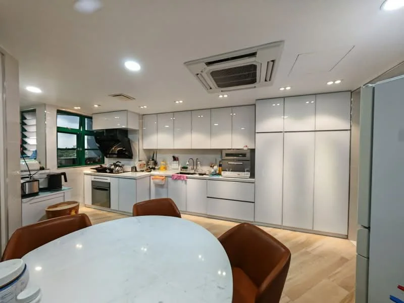 Kitchen features: white cabinetry with flat-panel doors, marble countertop, stainless-steel sink, chrome pull-down faucet, built-in oven, freestanding range oven, microwave, refrigerator, tile backsplash, recessed LED downlights, ceiling-mounted air conditioning unit, round dining table, upholstered dining chairs in brown, window with green view; style: modern; view: city.