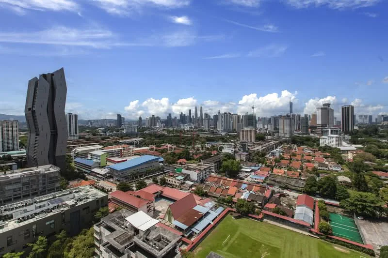 Exterior type: high-rise condominium; features: city skyline view, modern architectural design, surrounded by greenery, mixed-use development, near residential area, visible sports field, urban landscape, high-rise buildings in background; style: modern.