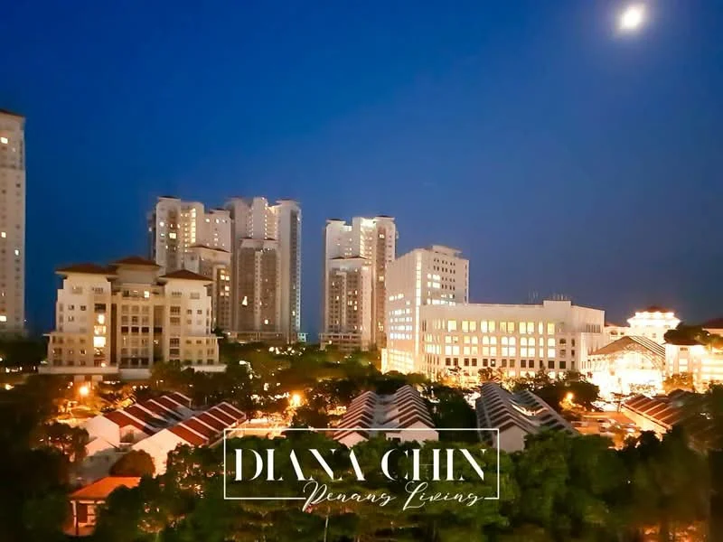 Exterior type: high-rise condominium; features: night view with illuminated buildings, multiple high-rise buildings, surrounding low-rise houses, landscaped greenery in foreground, moon visible in sky, urban skyline, well-lit streets, varied architectural styles; style: modern.