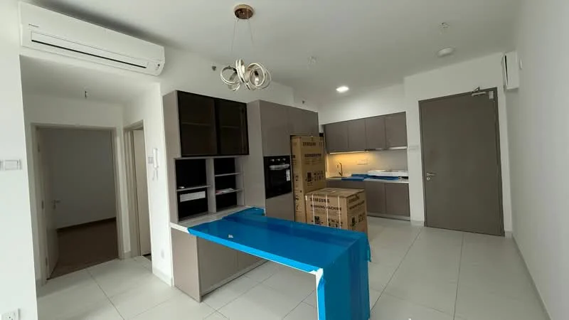 Kitchen features: white walls, light grey cabinetry, kitchen island with blue protective covering, built-in oven, built-in microwave, stainless-steel sink, chrome pull-down faucet, ceramic tile flooring, recessed downlights, 1 wall-mounted split AC, open shelving, boxes stacked on the floor; style: modern. Room features: cream painted walls, light grey doors, tile flooring.