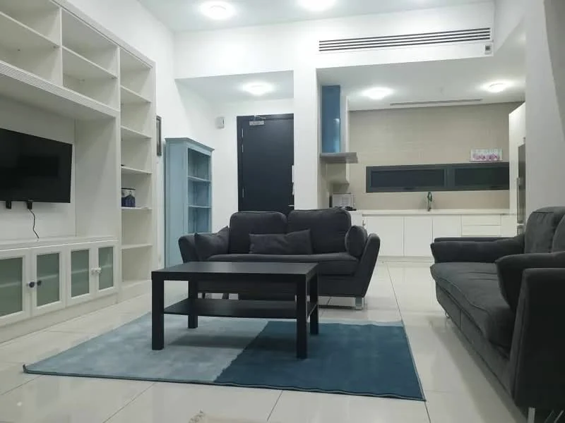 Living features: grey fabric 3-seater sofa, grey fabric 2-seater sofa, black coffee table, light blue area rug, white built-in shelving unit, white TV console with glass doors, wall-mounted TV, recessed ceiling lights, white walls, glossy white tile flooring, large window with green view, kitchenette area visible in background; style: modern.