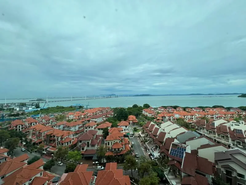 Exterior type: linked terrace house; features: red tiled roofs, solar panels on rooftops, manicured lawns, surrounding greenery, view of the sea, city skyline in the background, multiple storey houses, paved walkways; style: modern.