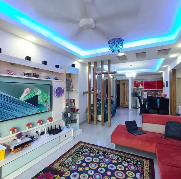 Living features: red fabric sofa, area rug with circular pattern, wall-mounted TV, entertainment unit with storage, ceiling fan with light, recessed LED downlights, decorative chandelier, feature wall with wooden accents, white painted walls, glossy tile flooring, open layout to kitchen, blue LED strip lighting; style: modern.