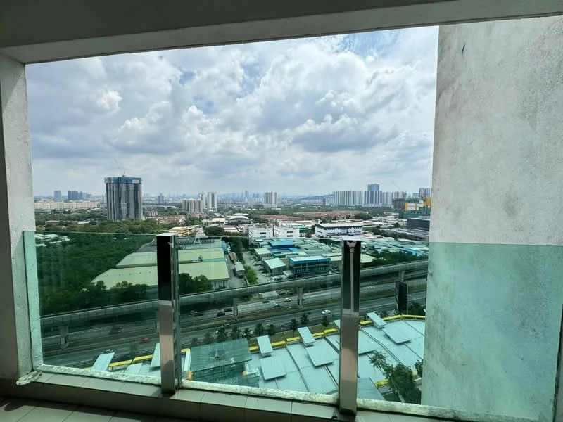 Room features: floor-to-ceiling windows, glass balcony railing, city skyline view, cloudy sky, urban landscape, high-rise buildings in distance, greenery visible below, highway visible below; style: modern; view: city.
