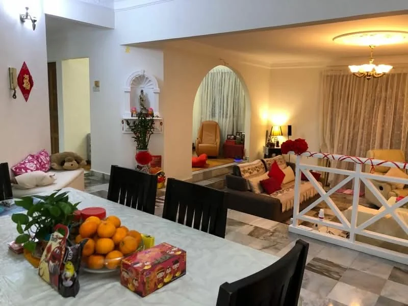 Dining features: dining table with white tablecloth, black dining chairs, decorative fruit bowl with oranges, red decorative box, marble flooring; style: modern. Living features: sofa with red and beige cushions, coffee table, area rug, floor lamp, chandelier, curtains, wall-mounted decorative shelf, potted plants, wooden partition; style: modern.