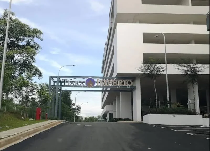 Exterior type: low-rise apartment block; features: white painted facade, flat roof, manicured landscaping, driveway with interlocking pavers, signage at entrance, surrounded by greenery; style: modern.