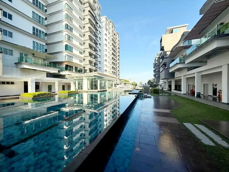Exterior type: high-rise condominium; features: swimming pool with reflective surface, landscape garden with manicured grass, modern glass facade, balconies with glass railings, stone-paved walkway, multiple storeys, surrounded by greenery, outdoor seating area; style: modern.