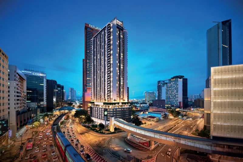 Exterior type: high-rise condominium; features: glass curtain wall, illuminated facade, recessed balconies, surrounded by urban landscape, multi-storey structure, adjacent to main road, pedestrian bridge, city skyline in background; style: modern.