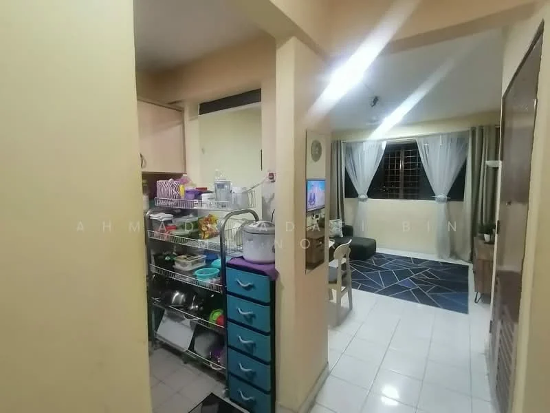 Kitchen features: white painted walls, ceramic tile flooring, open shelving, kitchen cart with drawers, dish rack, sink, countertop, refrigerator. Living features: sofa, coffee table, TV console, area rug with geometric pattern, curtains, wall-mounted TV.