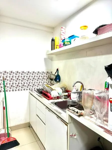 Kitchen features: white cabinetry, double-bowl stainless-steel sink, chrome pull-down faucet, ceramic tile backsplash with floral pattern, countertop with clutter, kitchen utensils on shelf, dishes and glasses on countertop, cleaning supplies visible, tile flooring, wall-mounted shelf.