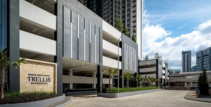 Exterior type: multi-storey car park; features: concrete facade, grey painted facade, feature wall with decorative panels, landscaped garden with palm trees, manicured lawn, driveway with interlocking pavers, signage for Trellis Residences, surrounded by high-rise buildings, modern architectural design; style: modern.