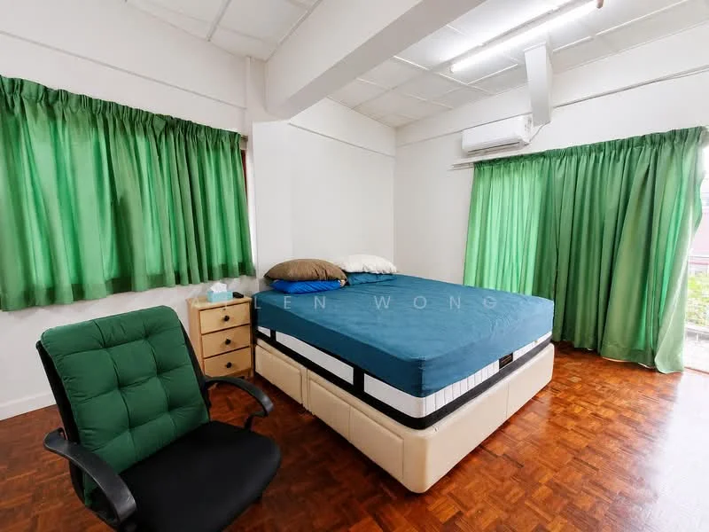 Bedroom features: queen-size bed with blue mattress, green curtains, white walls, wooden flooring, air conditioning unit, black office chair, wooden bedside table.