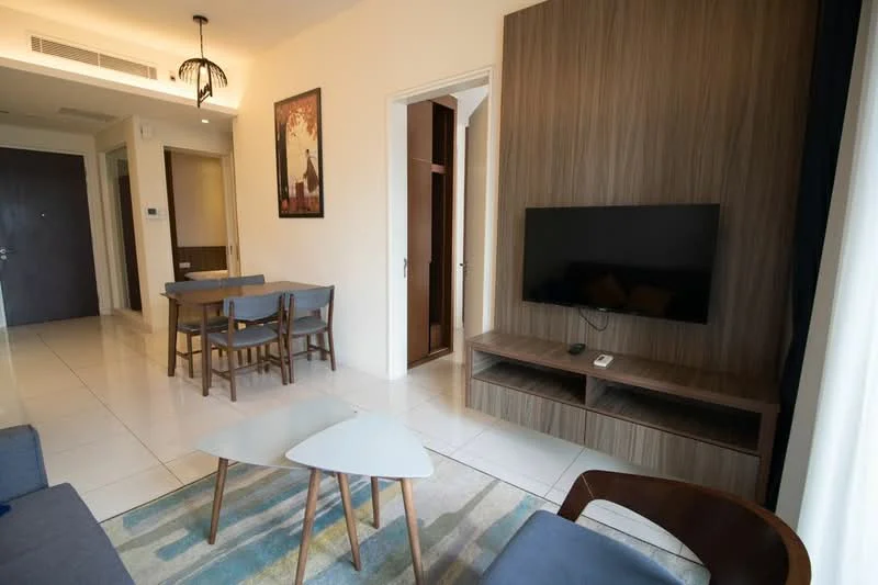 Living features: grey fabric sofa, wooden coffee table, two small side tables, wall-mounted TV, wooden TV console, framed artwork on wall, recessed lighting, white walls, tile flooring, curtains, dining table with four chairs visible in background; style: modern.