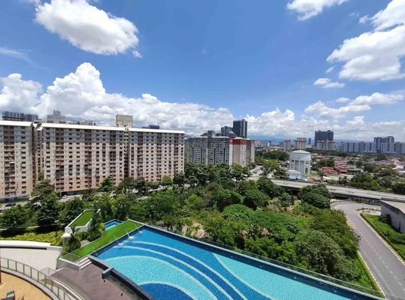 Exterior type: high-rise condominium; features: infinity pool, pool deck with loungers, manicured landscaping, surrounded by greenery, city skyline in background, multiple-storey residential building, road access visible; style: modern.