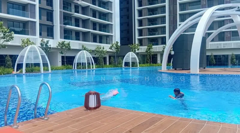 Exterior type: swimming pool deck; features: infinity pool, pool deck with wooden flooring, white modern cabanas, landscaped greenery around pool, poolside lighting, swimmers in pool, surrounding residential buildings, blue water; style: modern.