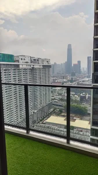 Room features: glass balcony railing, artificial grass flooring, city skyline view, high-rise building, cloudy sky; style: modern; view: city.