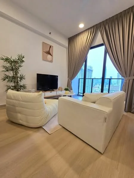 Living features: 2-seater white leather sofa, 3-seater cream fabric sofa, flat-screen TV on a white console, large floor-to-ceiling windows, sheer curtains, wooden flooring, decorative indoor plant, area rug, wall art with abstract design, recessed ceiling lights; style: modern; view: city.