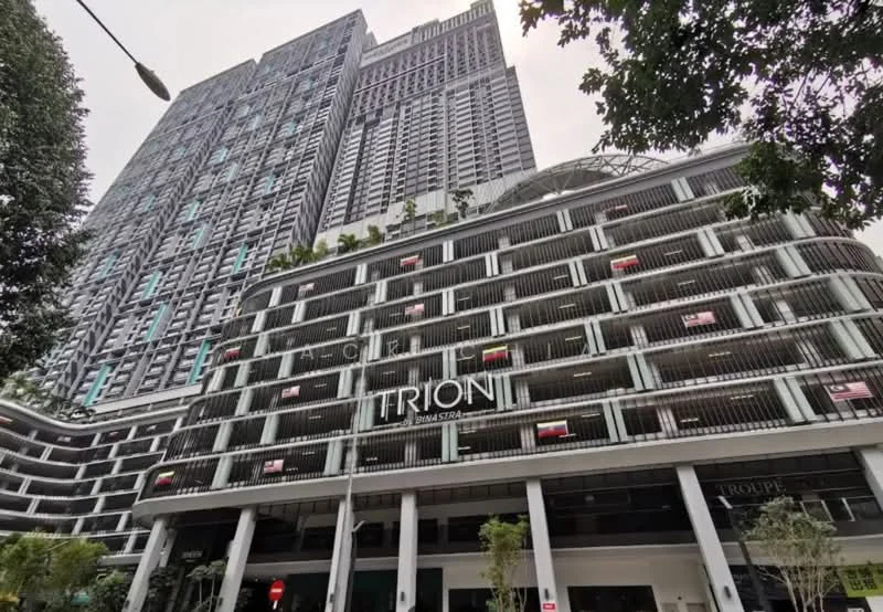 Exterior type: high-rise condominium; features: glass curtain wall, white painted facade, recessed balconies, multiple storeys, landscaped greenery at base, signage with 'TRION', parking deck, feature lighting, urban context with surrounding buildings; style: modern.