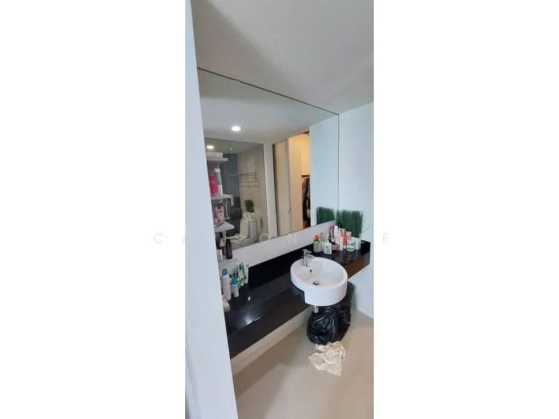 Bathroom features: single-sink vanity with black countertop, round white basin, large wall mirror, white painted walls, light-colored flooring, shelf with toiletries, green decorative plants, overhead lighting; style: modern.